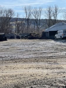 Mounds of gravel and wood scraps on a waste processing site.