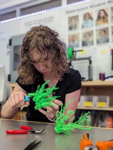 Lauren Mukavitz ‘27: In the Makerspace taking the supports off my finished models