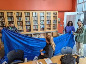 Staff and faculty examining Zea Barker's fabric for Tsedaye Makonnen’s Astral Sea series. From left to right: Kyle Yager, Samantha Pasapane, Tsedaye Makonnen, and Sandra Burton.