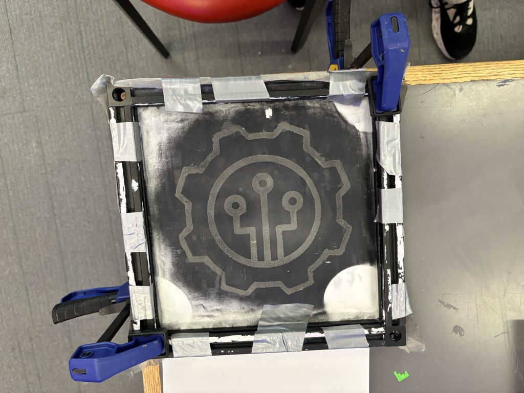 The result of using a laser cutter to burn acrylic paint off of a painted steel mesh screen. Instant "silk screen". Or is it?