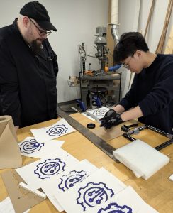 A test for new solutions: Jason Mativi and Stephen Sabio experimenting with alternative methods after multiple laser engraving challenges.