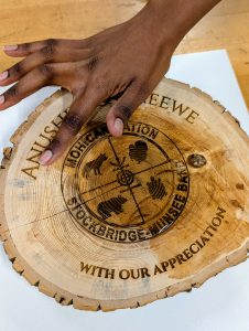 Divine Uwimana ‘27 puts non-toxic wood oil on the appreciation to protect and enhance the grain.