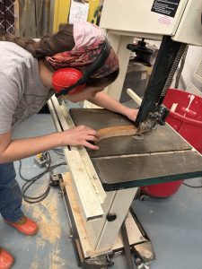 Using a bandsaw to cut one of the lyre's arms.