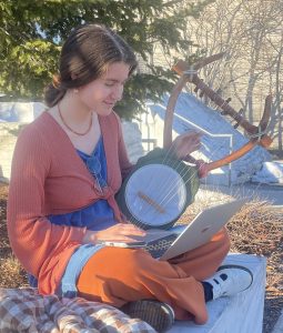 Sabrina Farrell sitting on the quad with the ancient Greek lyre that she built.