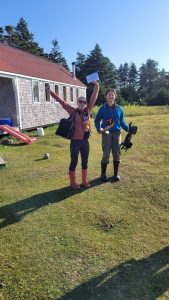 Kate Swann (‘26, left) and Hannah Cumming (‘28, right) excitedly preparing to conduct playback experiments on Kent Island. (Photo credit: Ian Kyle)