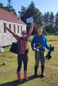 Kate Swann (‘26, left) and Hannah Cumming (‘28, right) excitedly preparing to conduct playback experiments on Kent Island. (Photo credit: Ian Kyle)