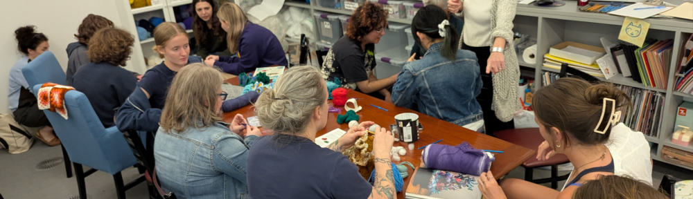 Participants in the Berkshire Satellite Reef Project's crochet workshop, led by Led by Rae Bravo ’28, Annie Trucano ’29, and Professor Amy Holzapfel (standing).