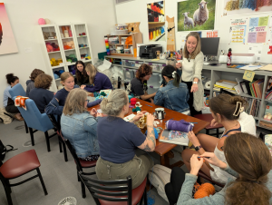 Participants in the Berkshire Satellite Reef Project's crochet workshop, led by Led by Rae Bravo ’28, Annie Trucano ’29, and Professor Amy Holzapfel (standing).