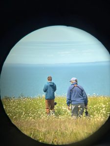 Henry Alexander '27 and Prof. Heather Williams in the field on Grand Manan, New Brunswick, Canada. Both Williams and Alexander carry microphones used to record bird songs. (Photo credit: Hannah Cumming)