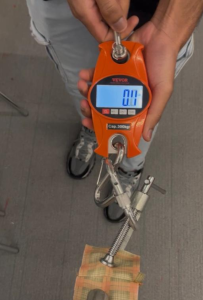 Harper Treschuk ‘25, Varya Kluev ‘25, and Tegra Ilunga '27 test seam durability using a digital crane scale