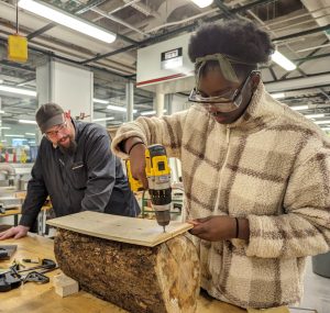 Sam Samuel '26 creating a temporary sled guide to saw logs into planks with bandsaw