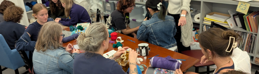 Participants in the Berkshire Satellite Reef Project's crochet workshop, led by Led by Rae Bravo ’28, Annie Trucano ’29, and Professor Amy Holzapfel (standing).